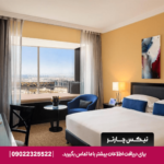 اتاق Window Seat Room با طراحی مدرن و صندلی کنار پنجره، منظره‌ای تماشایی از دبی و فضایی دلنشین برای استراحت یا مطالعه ارائه می‌دهد.
