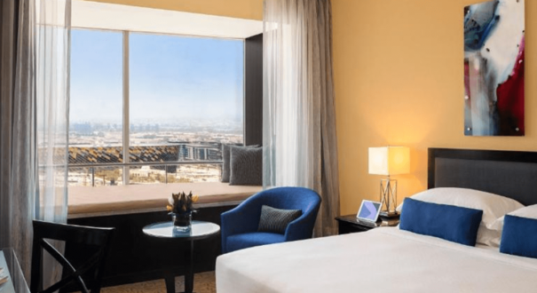 اتاق Window Seat Room با طراحی مدرن و صندلی کنار پنجره، منظره‌ای تماشایی از دبی و فضایی دلنشین برای استراحت یا مطالعه ارائه می‌دهد.